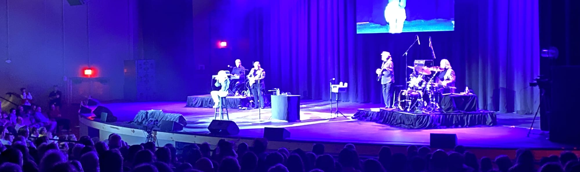signer on stage in chair washed out by the lights Greenville
